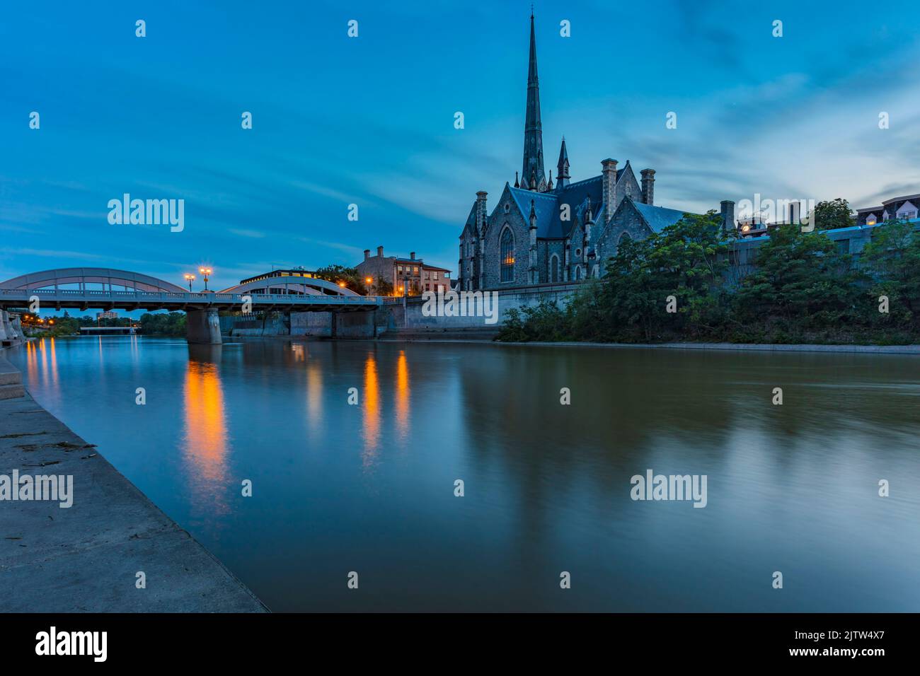 What photographers call Blue Hour casts a serene hue over the Grand River at Cambridge, Ontario, Canada, as the sun goes down. Stock Photo