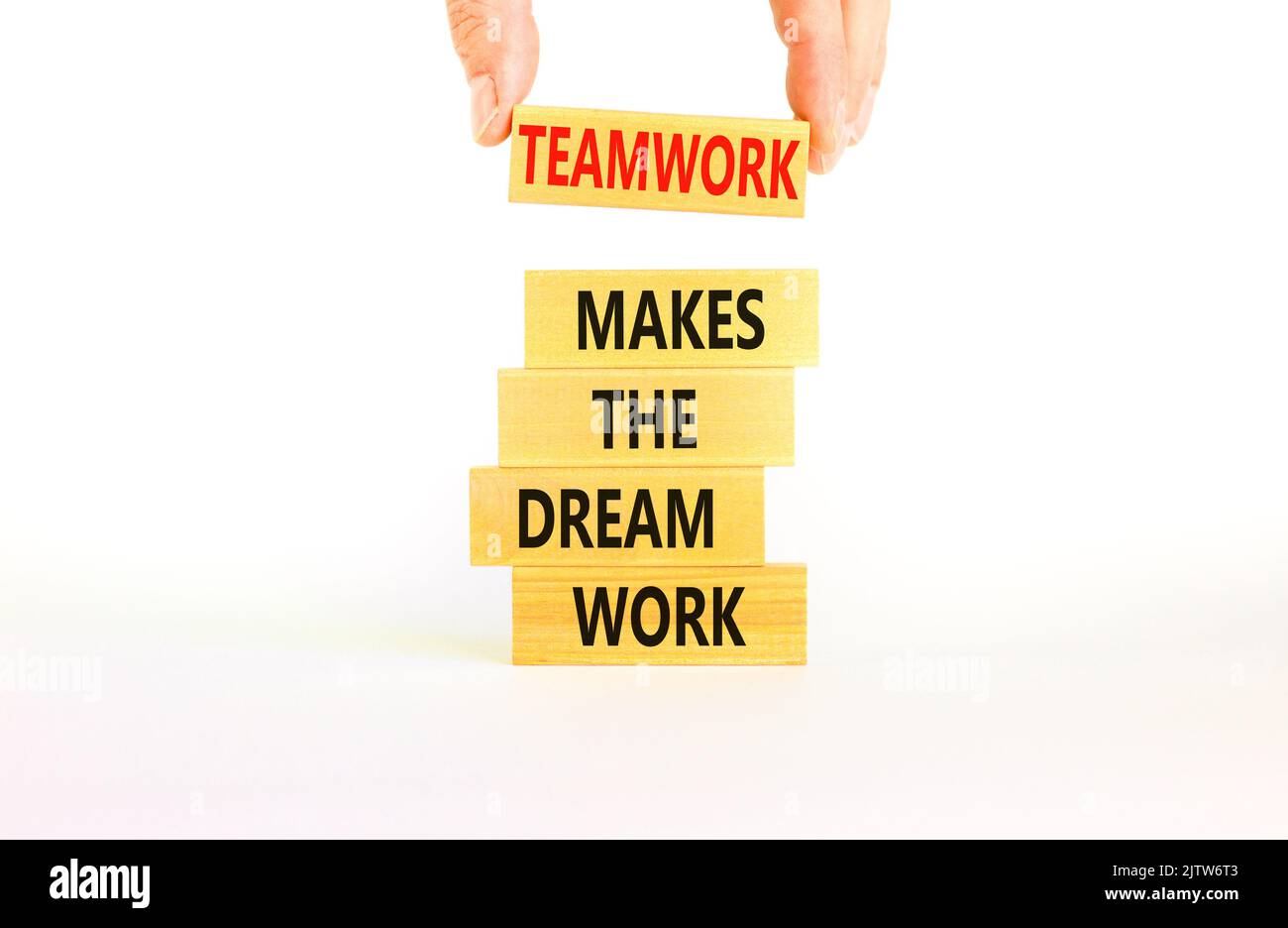 Teamwork makes dream work symbol. Concept words Teamwork makes the dream work on wooden blocks on beautiful white background. Businessman hand. Busine Stock Photo