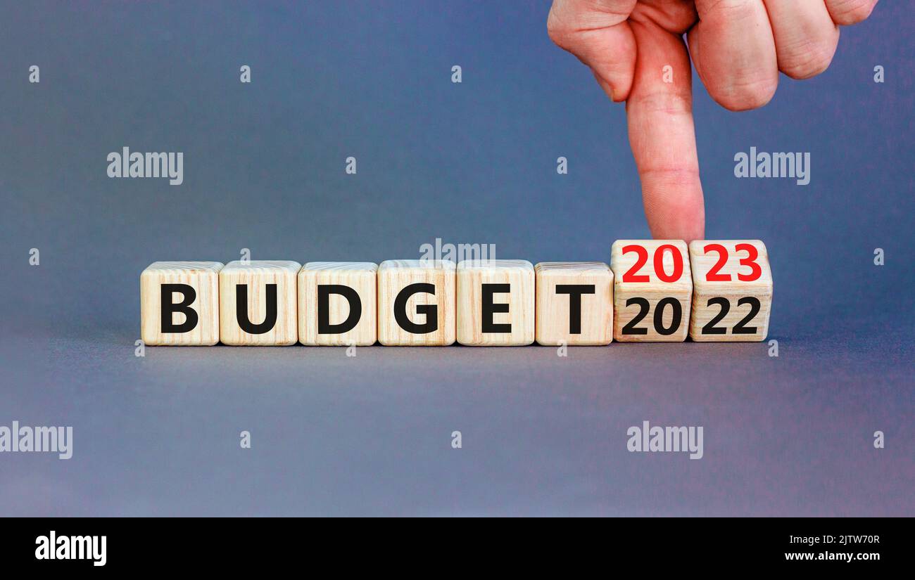 Planning 2023 budget new year symbol. Businessman turns a wooden cube