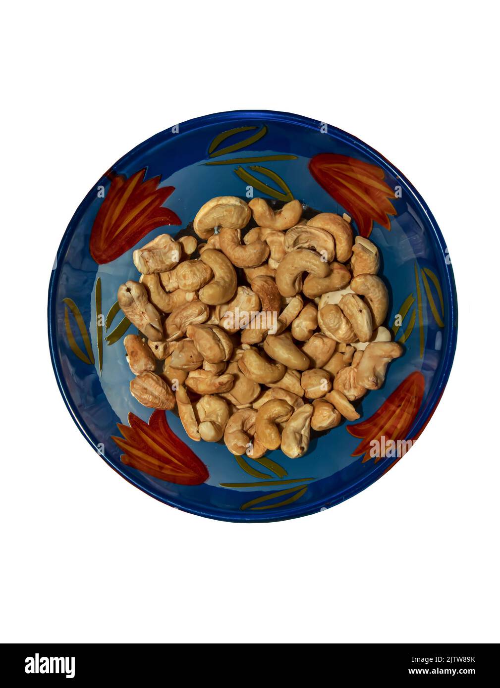 Roasted whole cashews in a glass blue bowl. Light brown nuts used as a