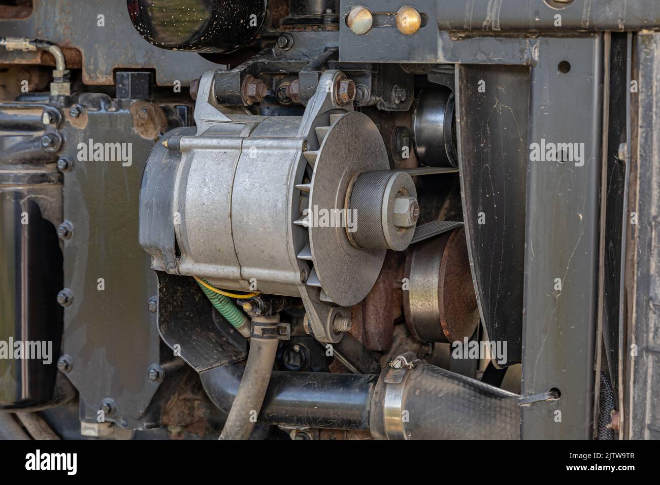 Alternator and serpentine belt on farm tractor. Agriculture and farming equipment repair, maintenance and service concept Stock Photo