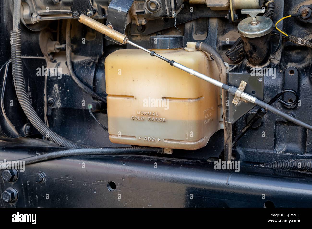 Antifreeze coolant tank on farm tractor cooling system. Agriculture and farming equipment repair, maintenance and service concept Stock Photo