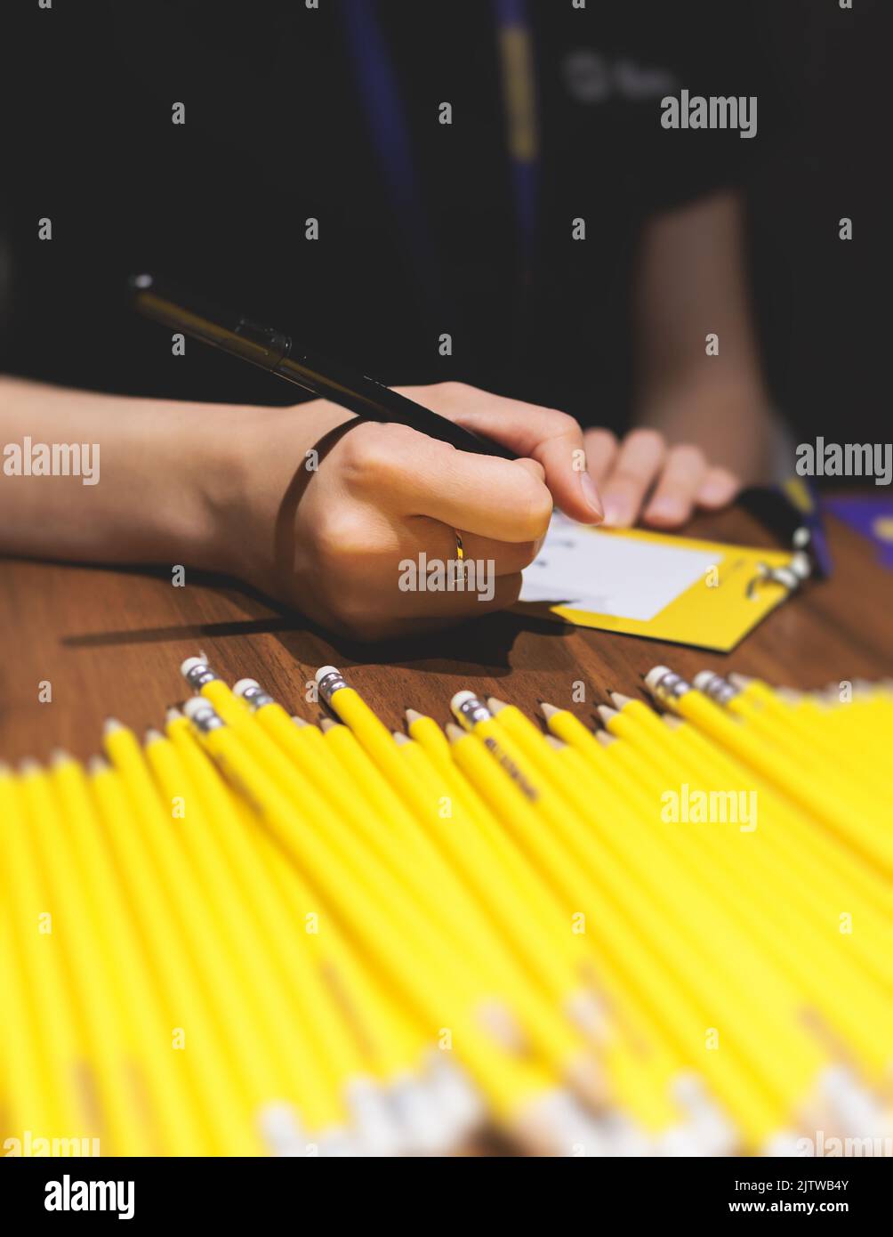 Process of checking in on a conference congress forum event, the registration desk table, visitors and attendees receiving a name badge and entrance w Stock Photo