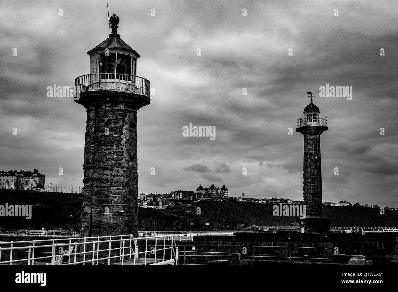 East and West lighthouse at Whitby with hotels and accommodation in the background Stock Photo