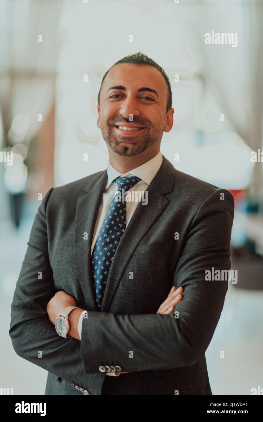 Portrait of a businessman in a suit with his arms crossed in a modern ...