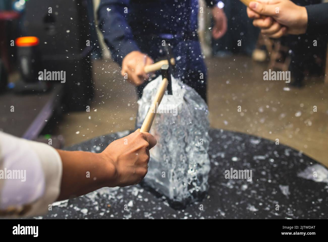 Process of breaking the ice with hammer and ice pick, group of people