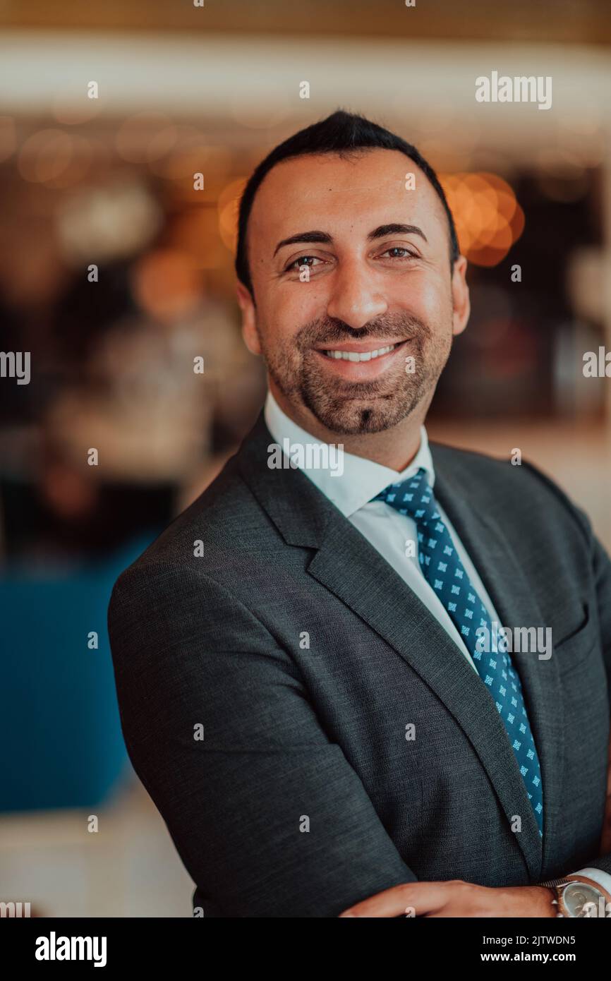 Portrait of a businessman in a suit with his arms crossed in a modern ...