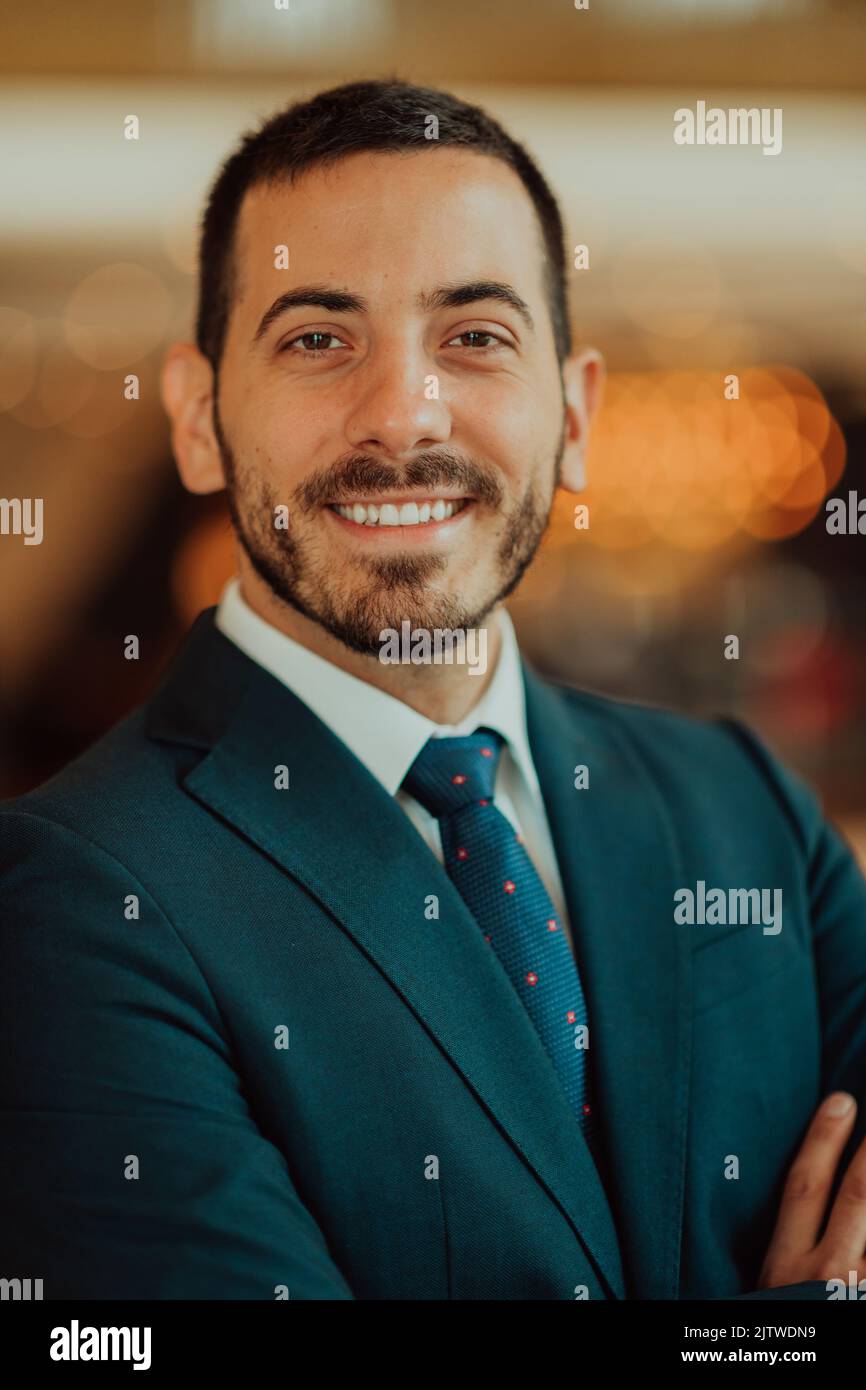 Portrait of a businessman in a suit with his arms crossed in a modern ...
