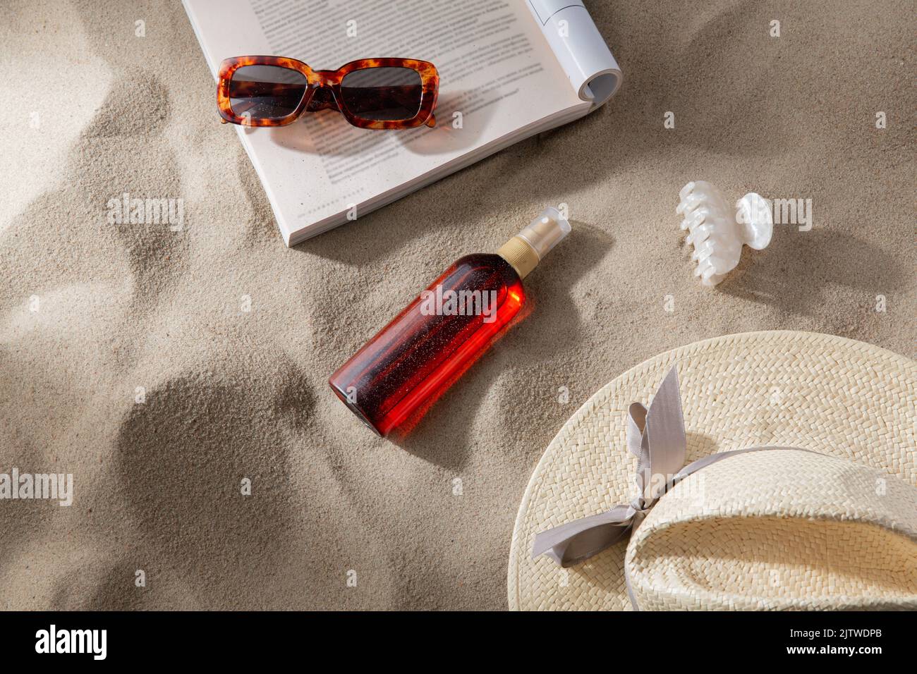 magazine, sunglasses and sunscreen on beach sand Stock Photo Alamy