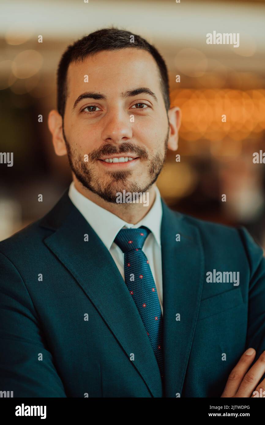 Portrait of a businessman in a suit with his arms crossed in a modern office building Stock Photo