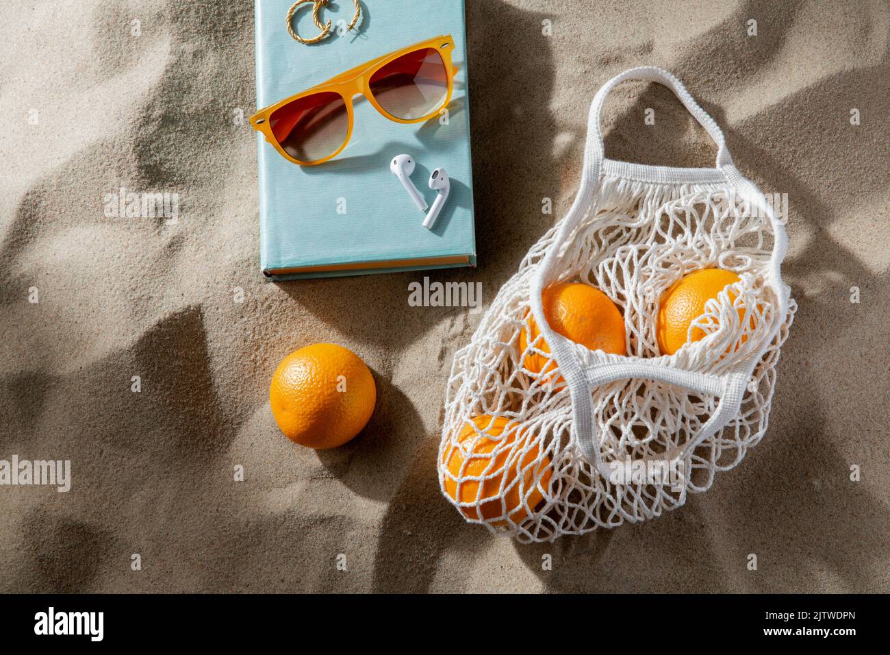 bag of oranges, earbuds and sunglasses on beach Stock Photo Alamy