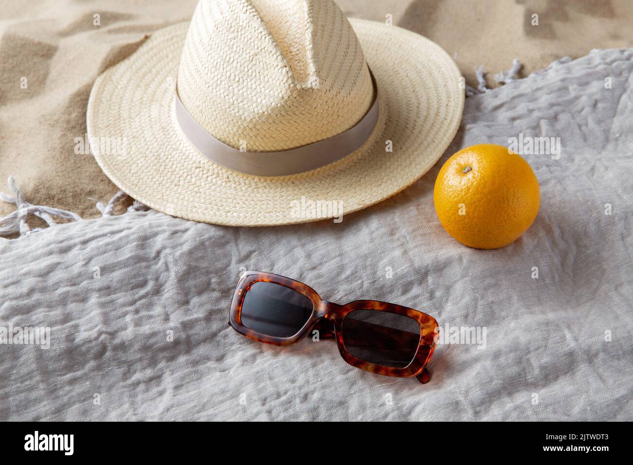 straw hat, sunglasses and orange on beach blanket Stock Photo - Alamy