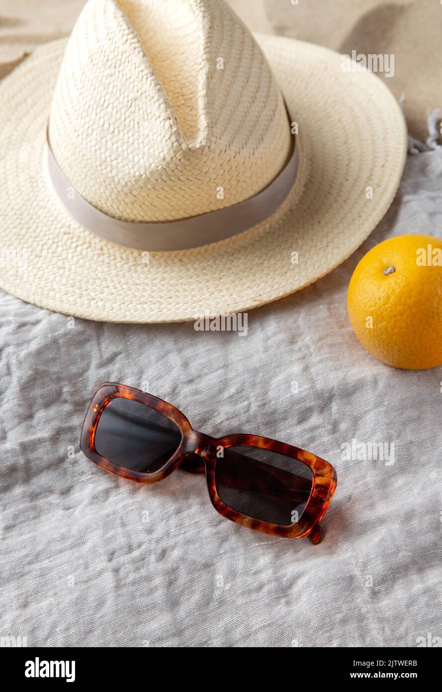 straw hat, sunglasses and orange on beach blanket Stock Photo - Alamy