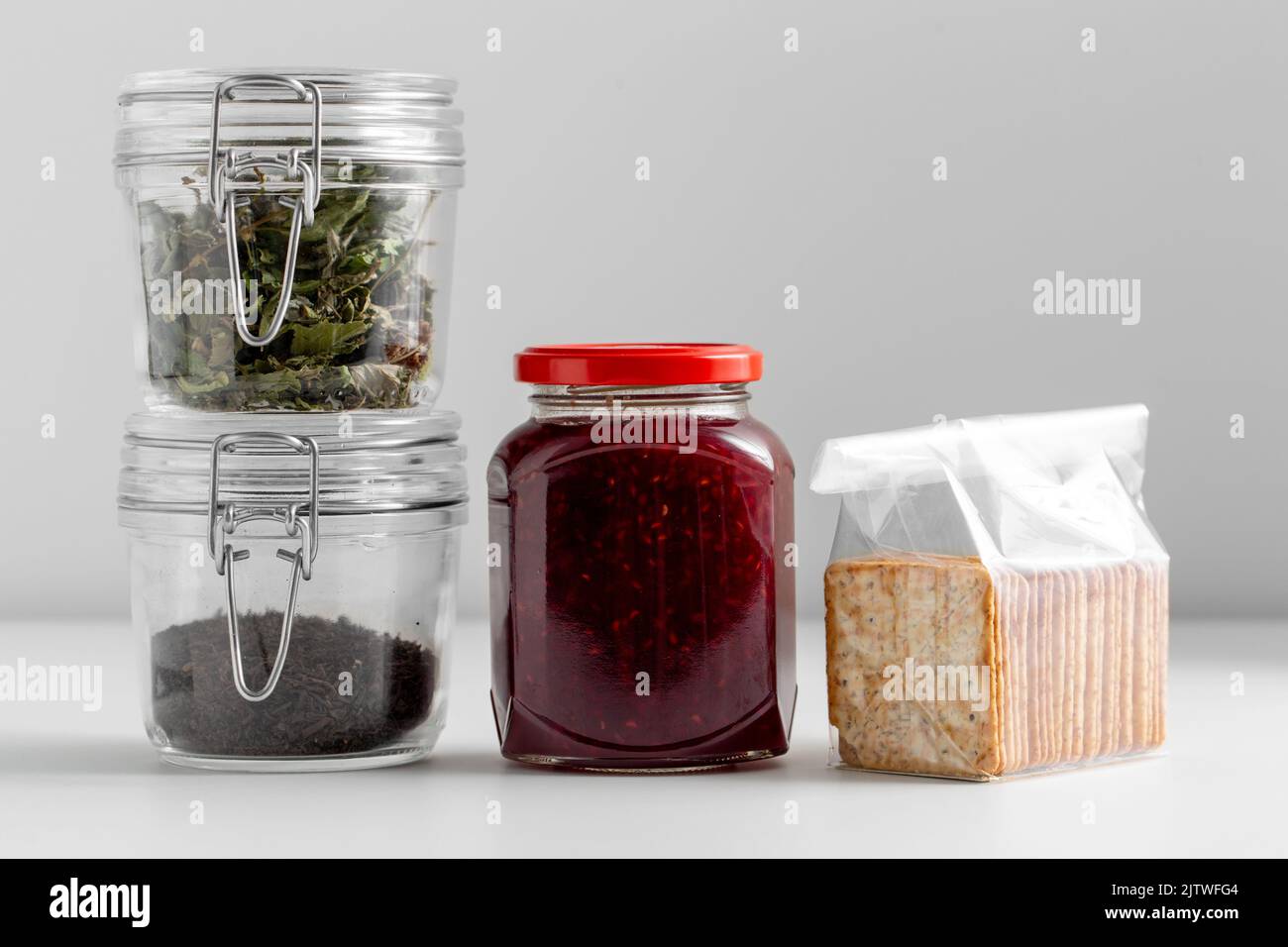 jars with dried herb, tea, jam and cookies Stock Photo