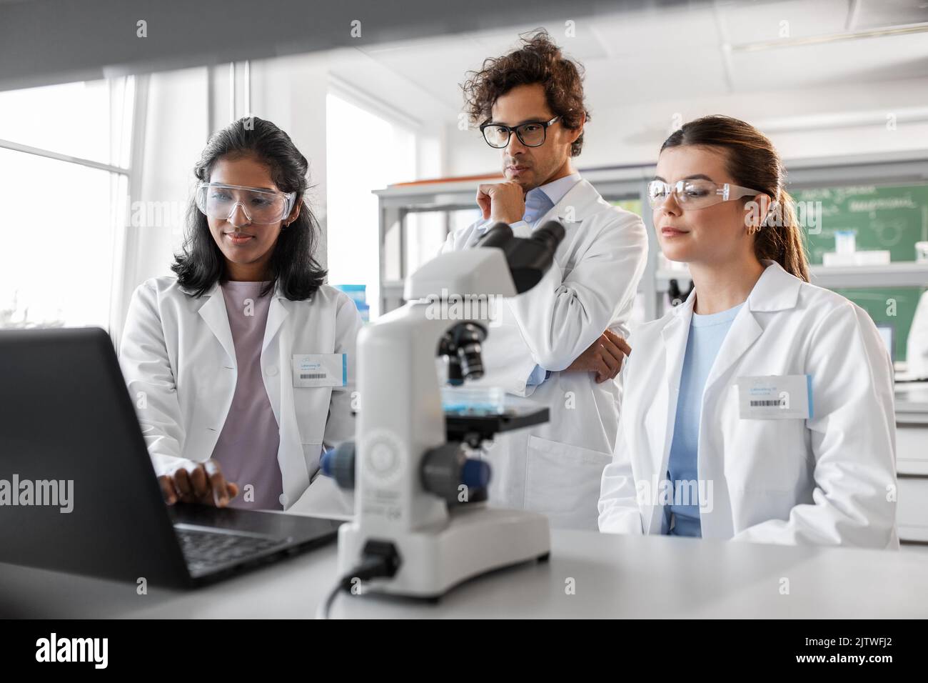 scientists with microscope working in laboratory Stock Photo