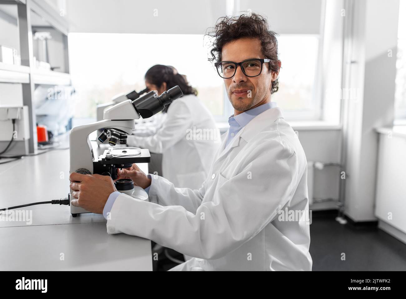 scientist with microscope working in laboratory Stock Photo Alamy