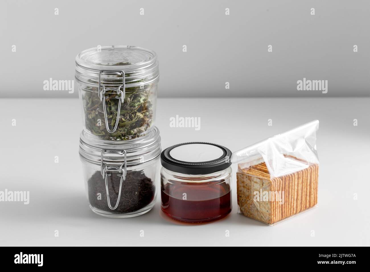 jars with dried herb, tea, honey and cookies Stock Photo