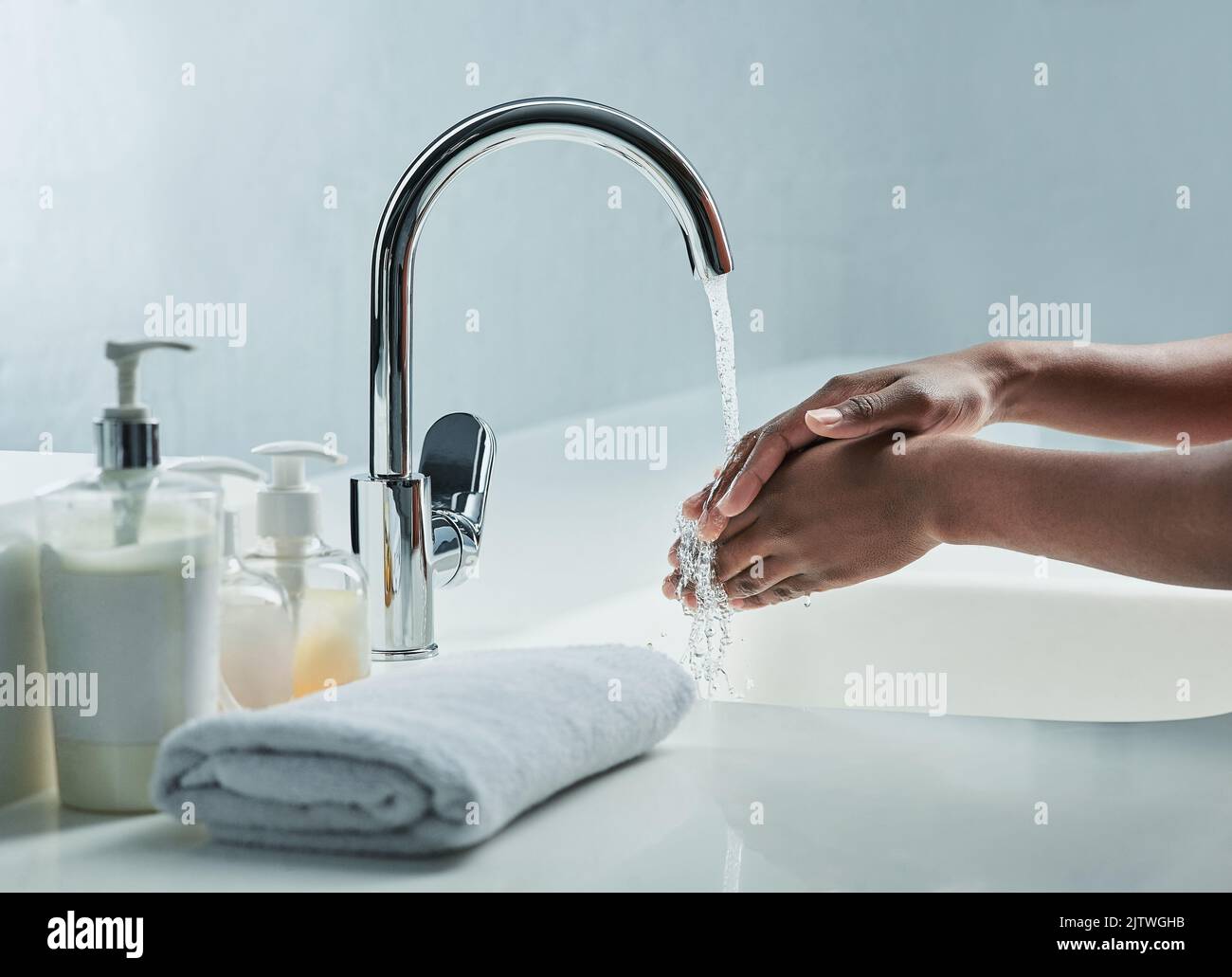 Say goodby to bacteria. a man washing his hands in a bathroom sink. Stock Photo