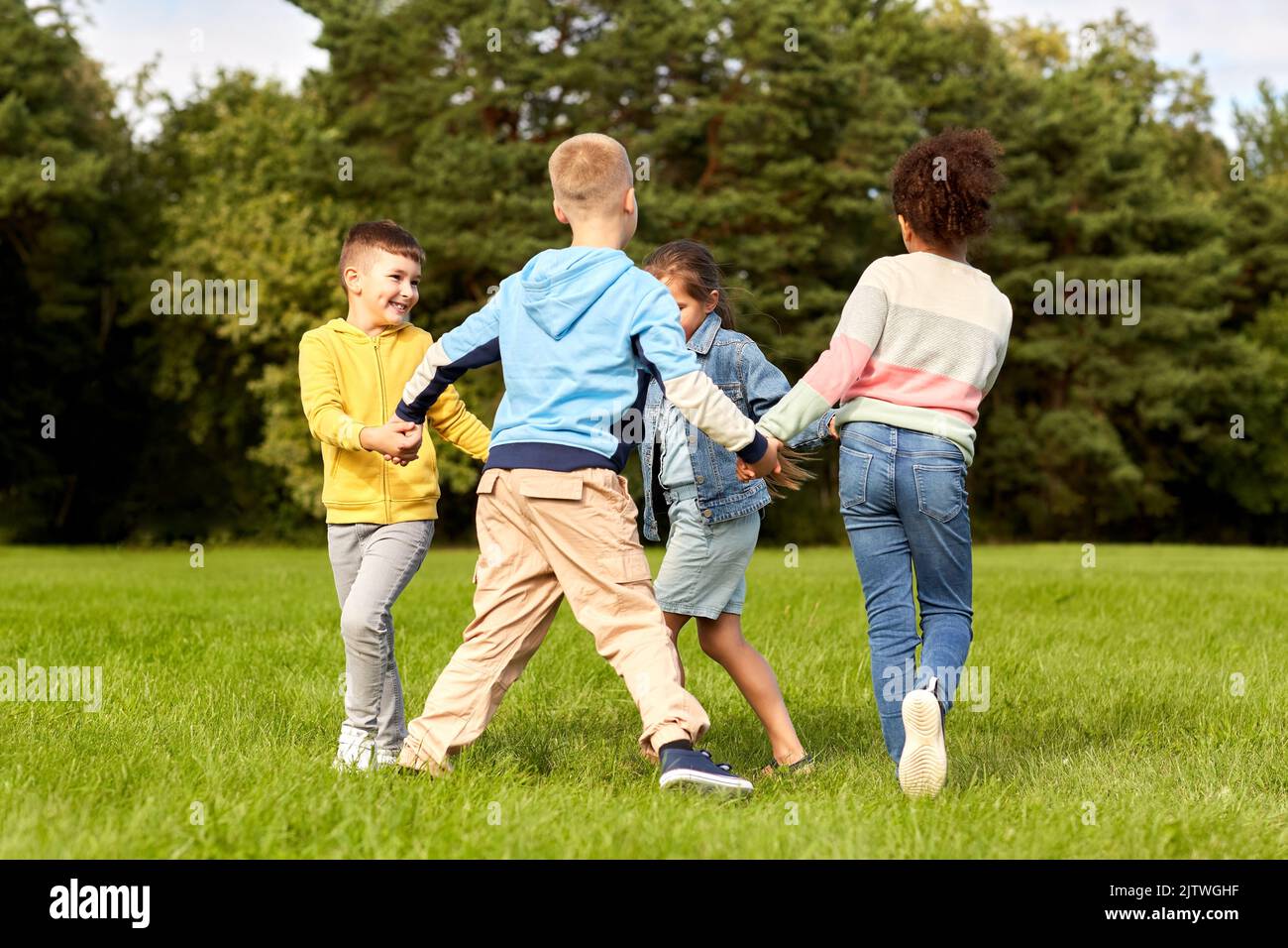 happy children playing round dance at park Stock Photo - Alamy