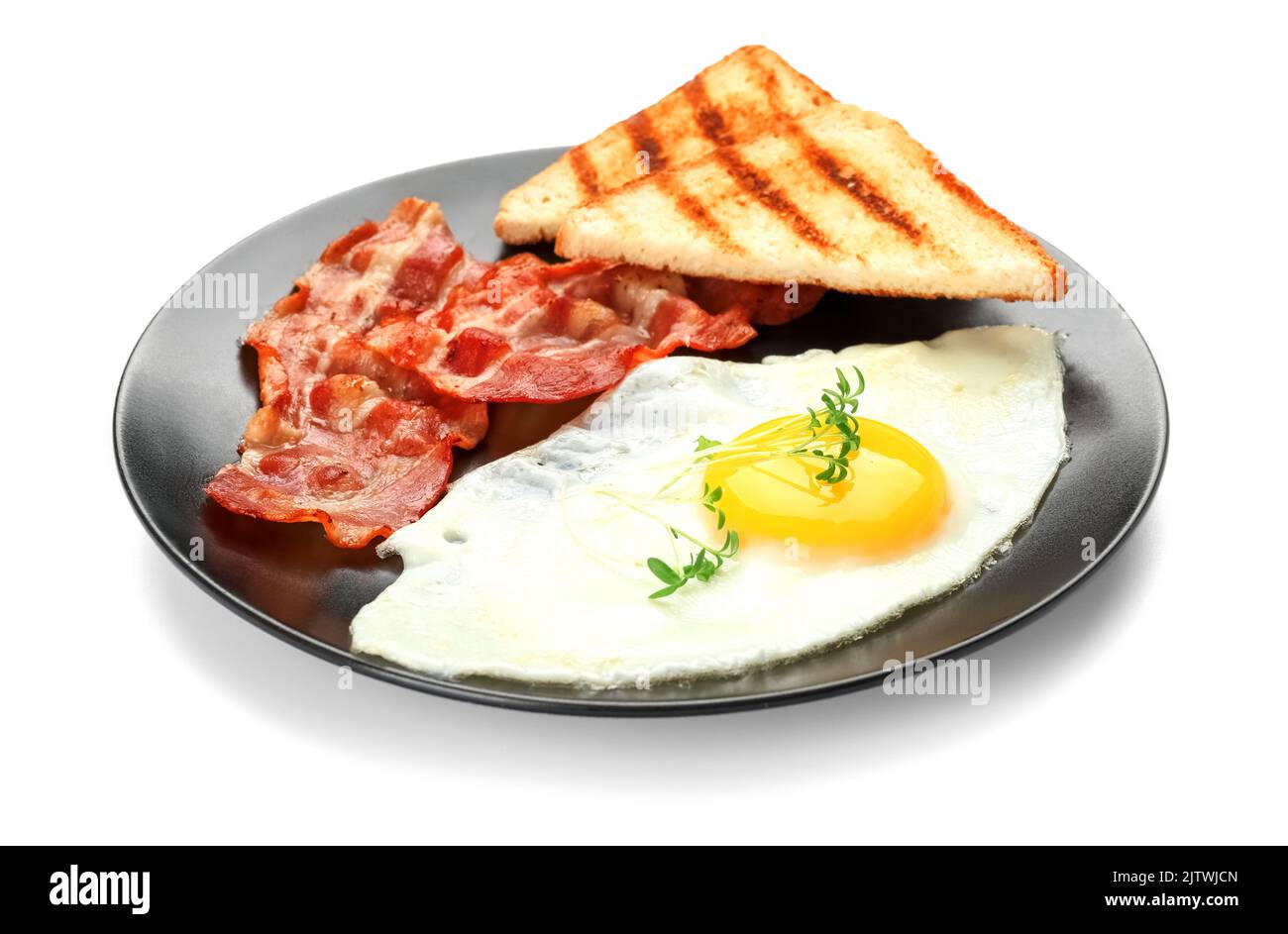 Plate with tasty fried egg, bacon and toasts isolated on white ...