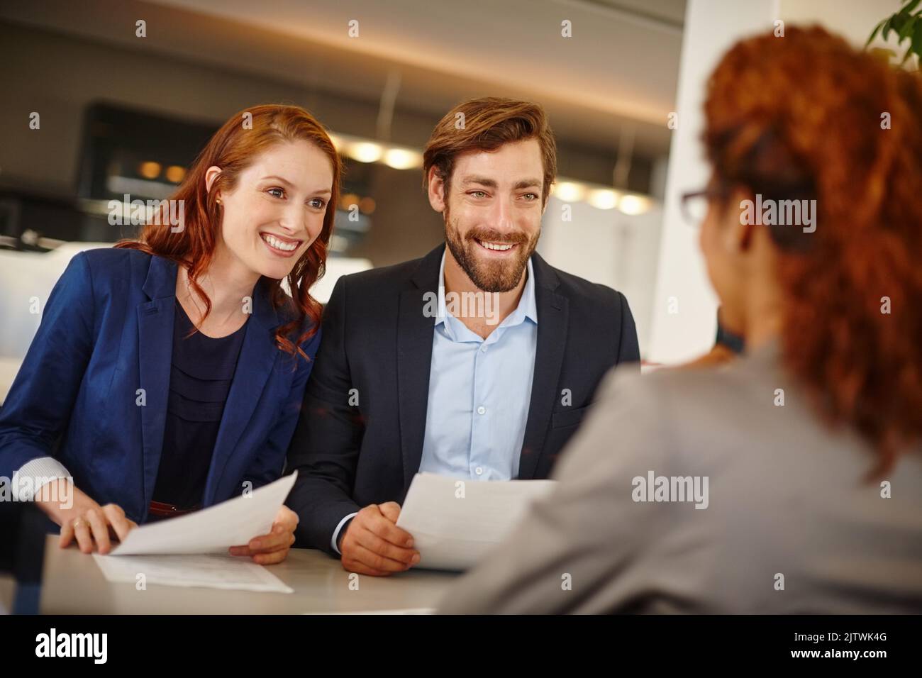 They like what she has to say. colleagues having a face to face meeting with a woman at work. Stock Photo