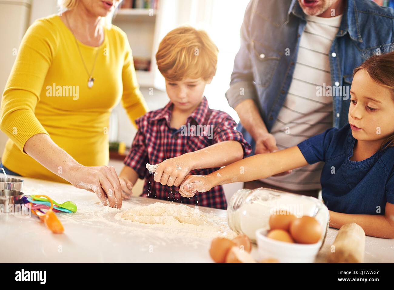 They share a love for baking. a family baking together at home. Stock Photo