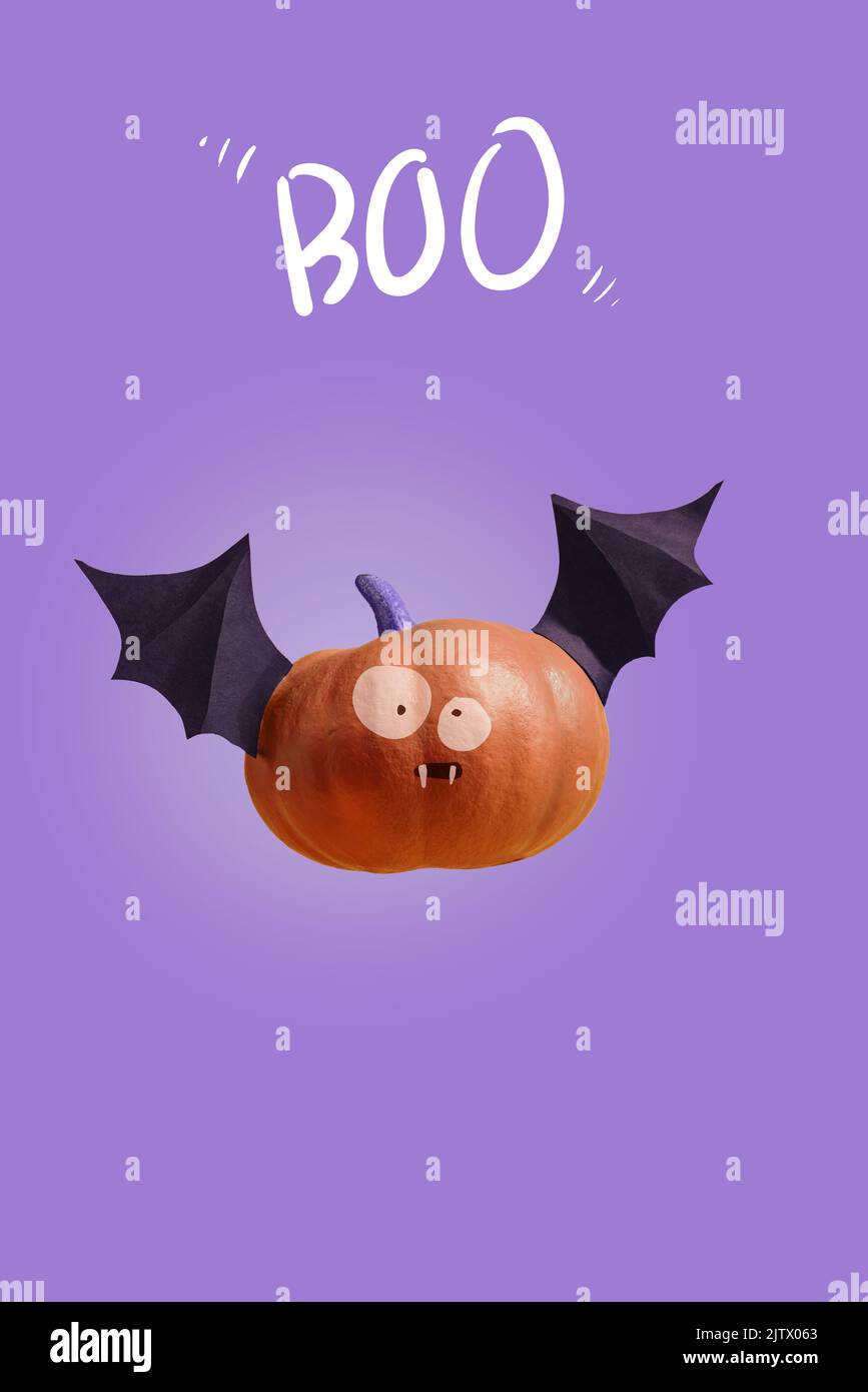 Happy Halloween, Funny pumpkin bat with frightening eyes lettering Boo, purple background. Festive background concept for party poster Stock Photo