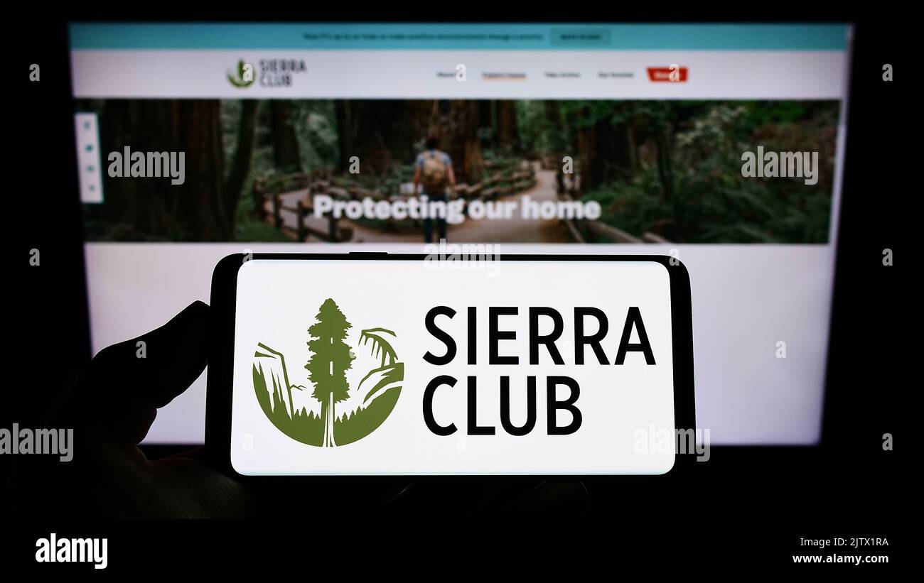 Person holding smartphone with logo of US environmental organization Sierra Club on screen in front of website. Focus on phone display. Stock Photo