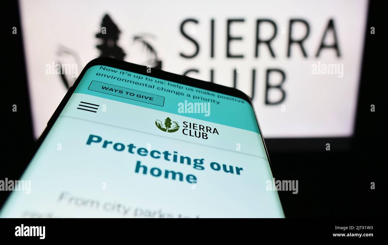 Mobile phone with website of US environmental organization Sierra Club on screen in front of logo. Focus on top-left of phone display. Stock Photo