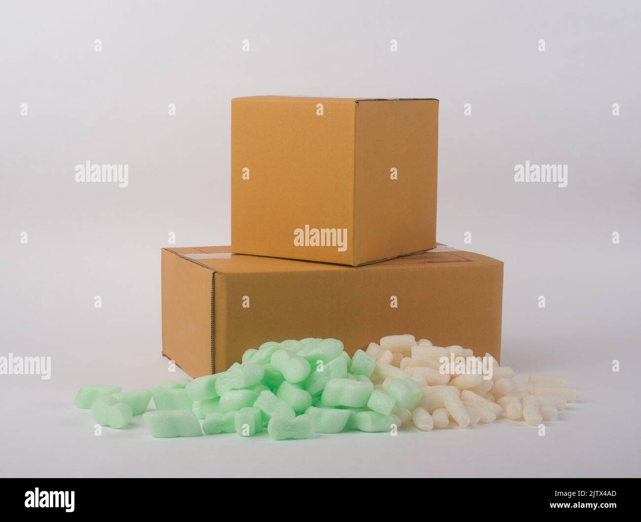 corrugated parcel boxes with shockproof bubbly plastic protective granules on white background, online business concept. Stock Photo