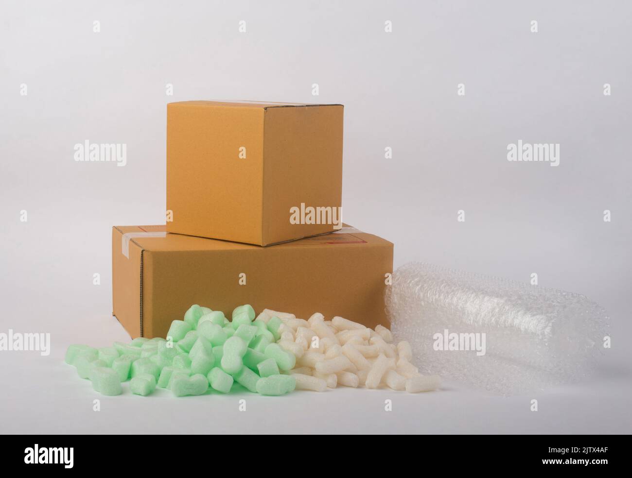 corrugated parcel boxes with shockproof material Polyethylene foam air bubble and bubbly plastic protective granules on white background, online busin Stock Photo