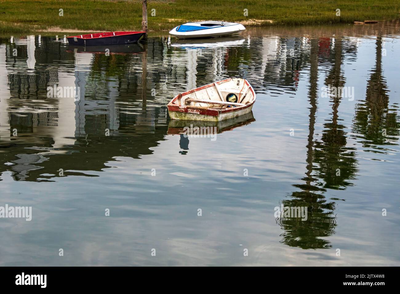 Reflection in the water of fishing boats standing on the pier in the sea bay. South Africa Stock Photo
