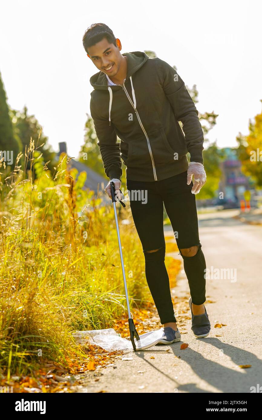 Smiling volunteer conserving environment from pollution and plastic Stock Photo