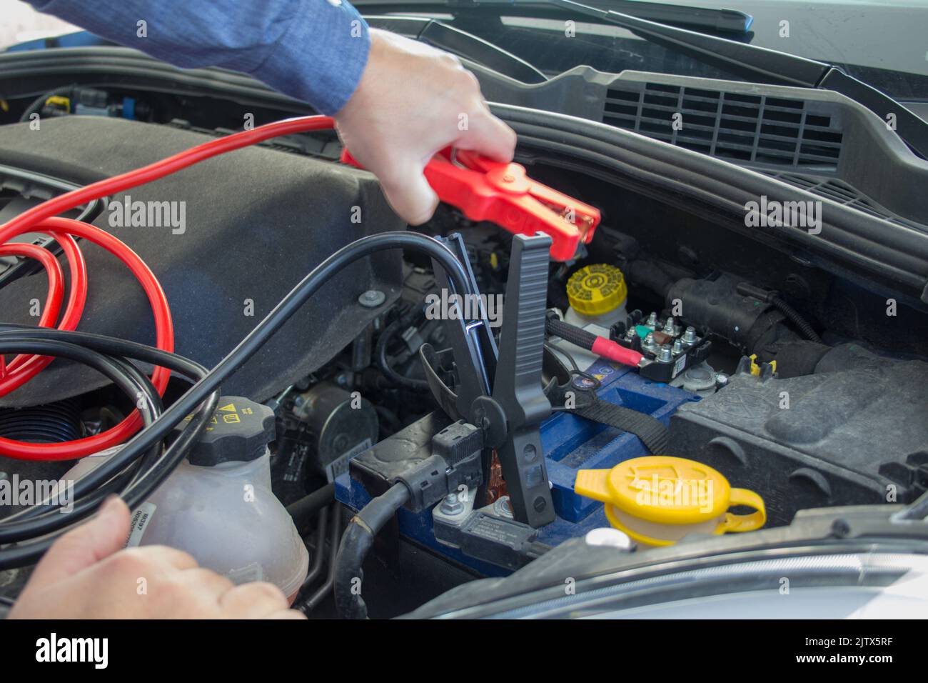 broken down car with low battery. Starting with cables Stock Photo Alamy
