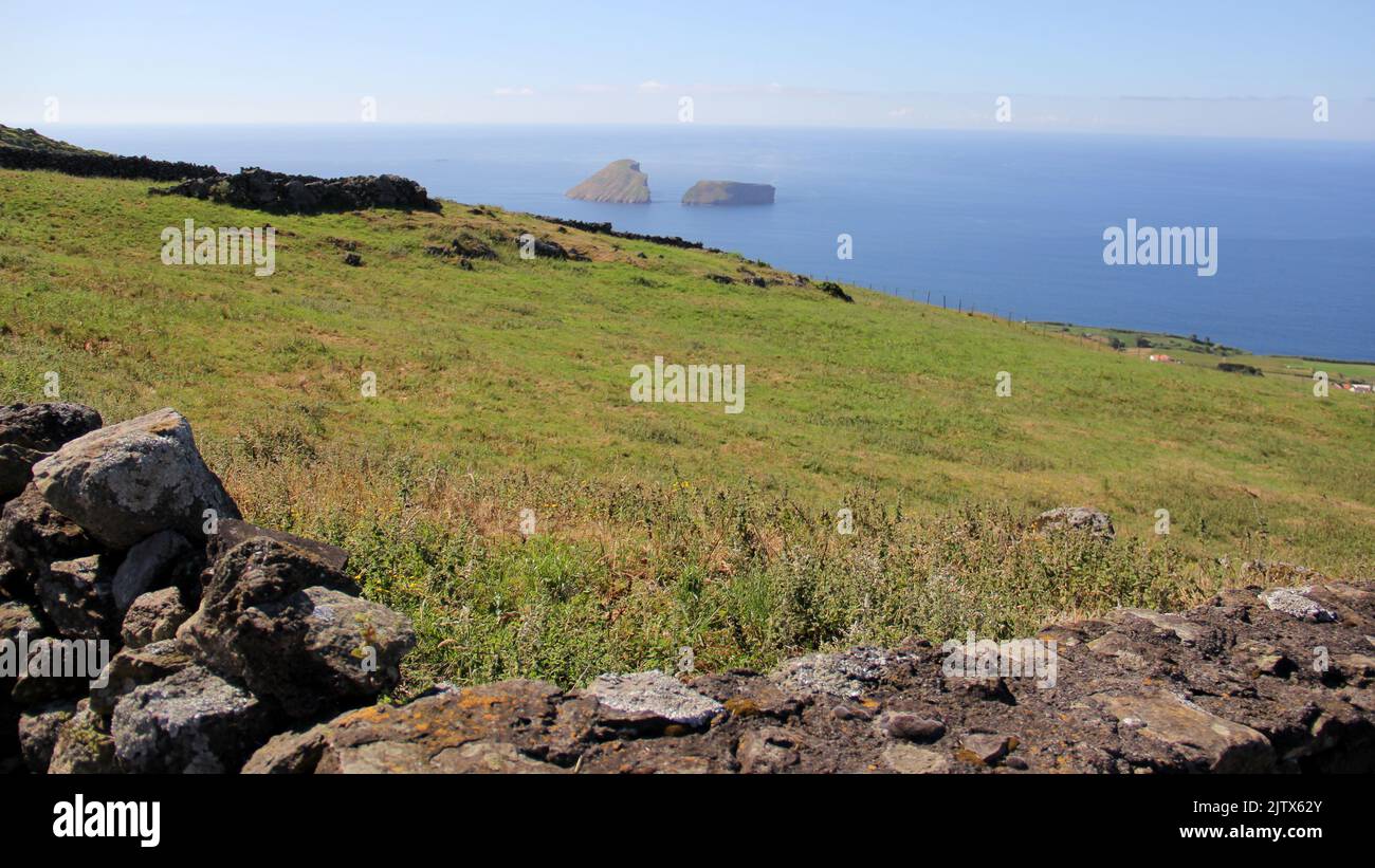 Rural landscape, pastures and stone fences, sloping toward the ocean, from Serra da Ribeirinha, Cabras Islets in the background, Terceira, Azores Stock Photo