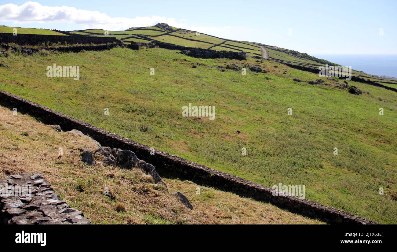 Rural landscape, green pastures and stone fences, sloping toward the ocean coast, view from Serra da Ribeirinha, Terceira Island, Azores, Portugal Stock Photo