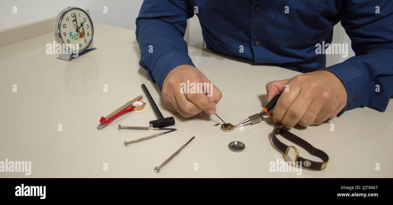 hands of a man while repairing watches. Watchmaker at work Stock Photo