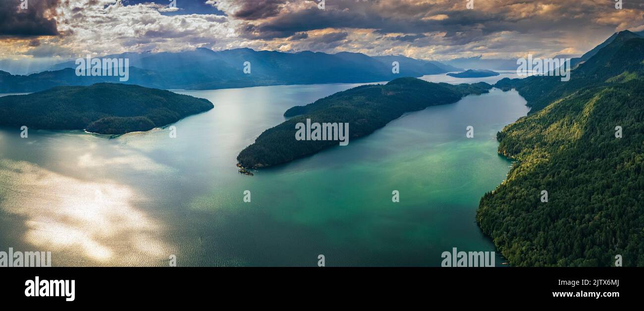 Panoramic format photo of a dramatic sunset sky over the Harrison Lake and the Long Island, Sasquatch Provincial Park, Harrison Hot Springs, British Stock Photo