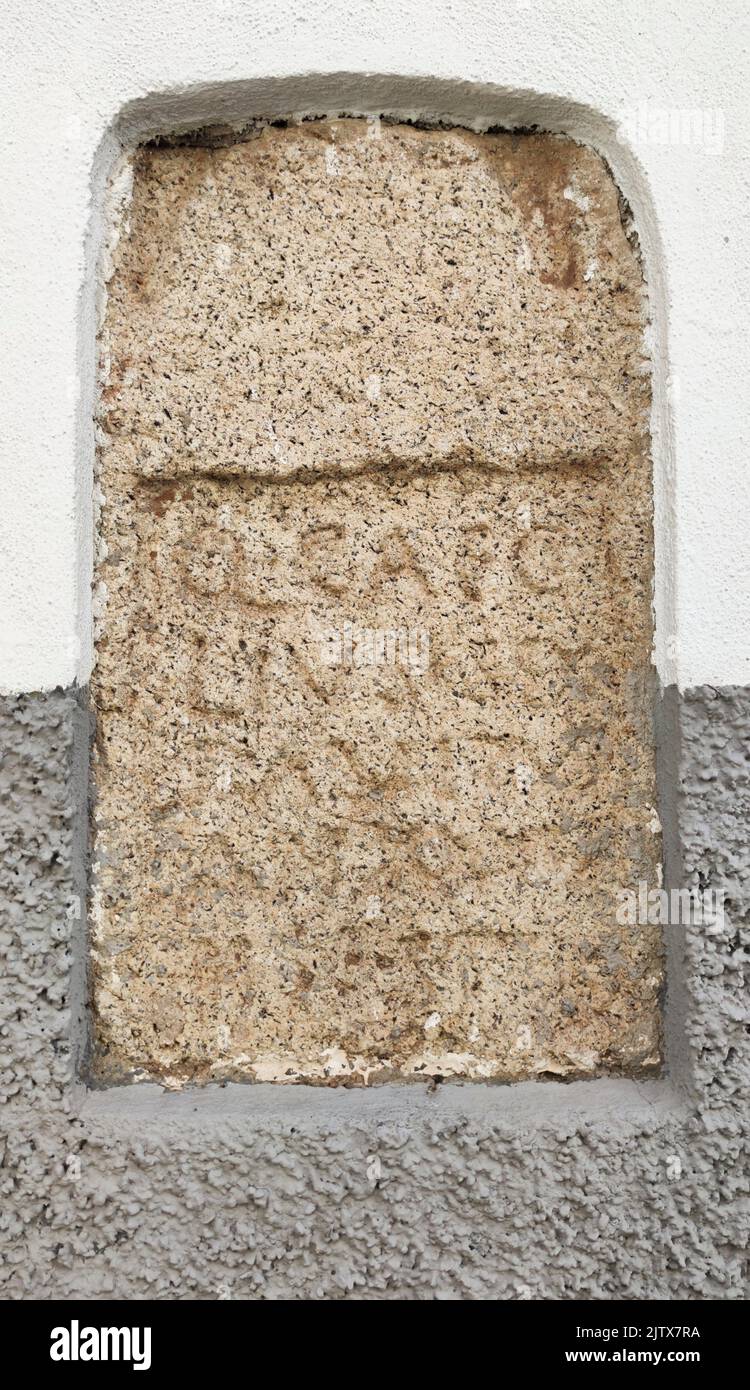 Roman tombstone built in historic quarter house. Merida gate, Caceres urban ensemble, Extremadura, Spain. Stock Photo