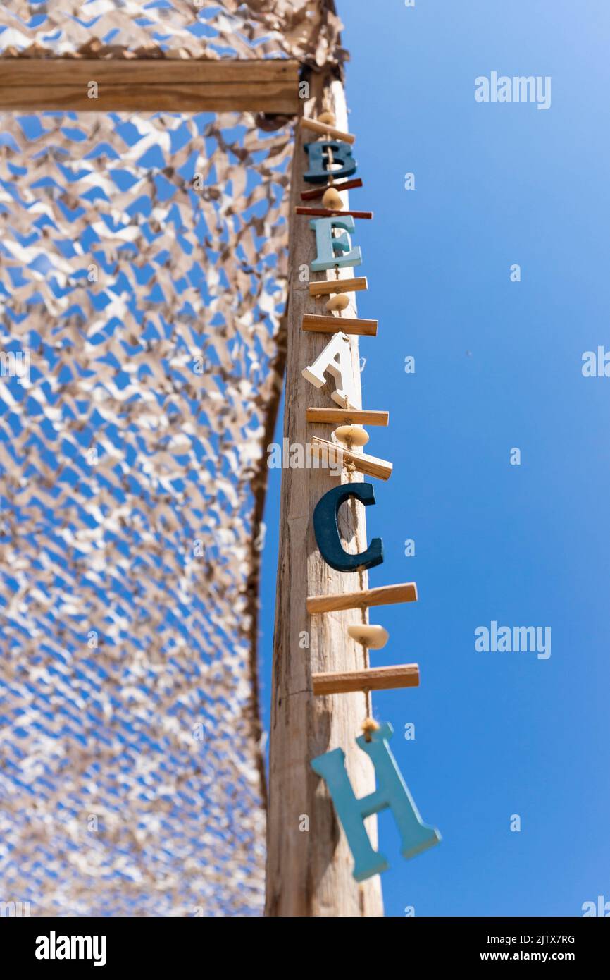 Beach sign. Wooden letters hanging from a post at beach bar. Stock Photo