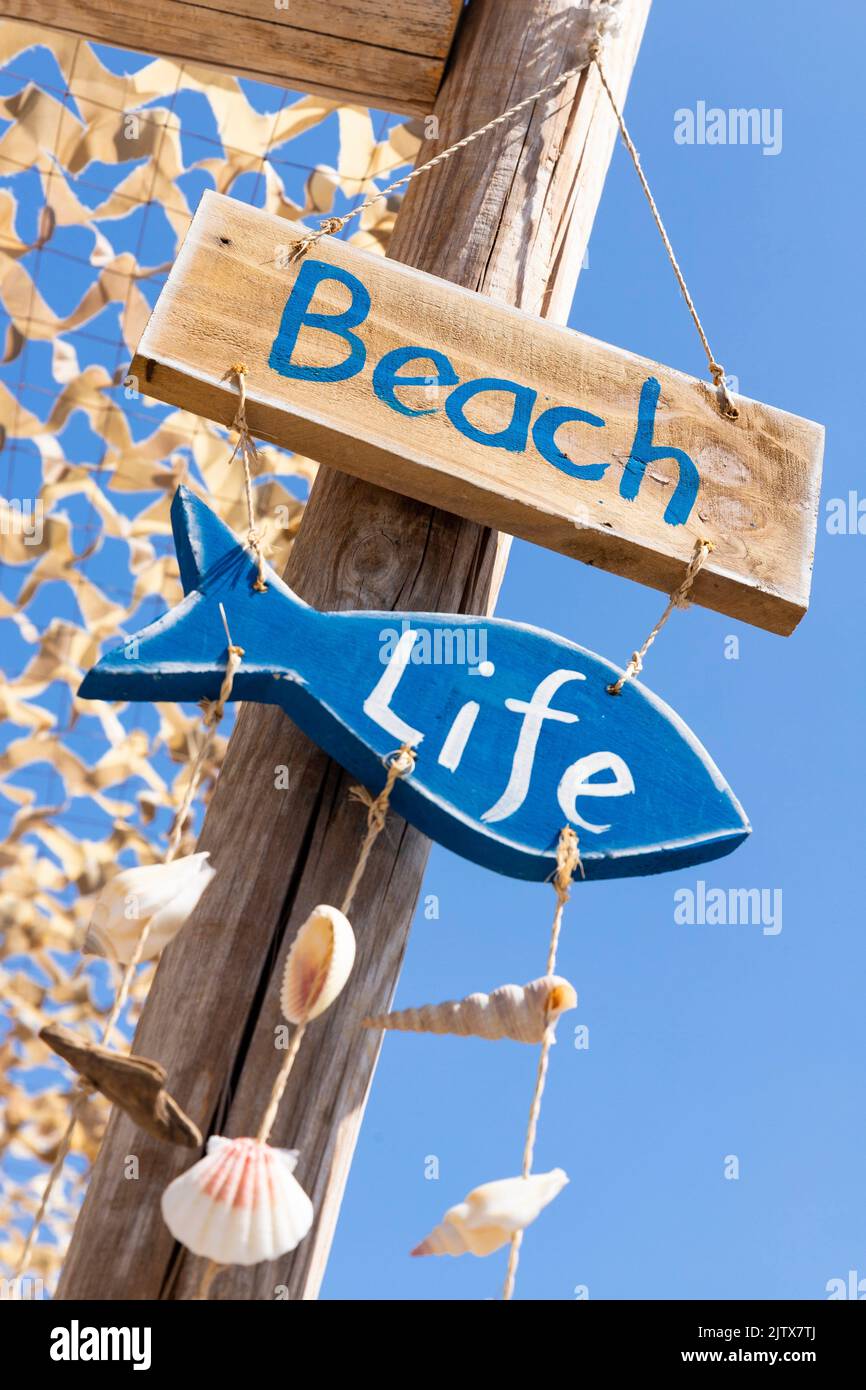 Wooden sign on the beach. Beach life. Summer signpost at the bar. Stock Photo