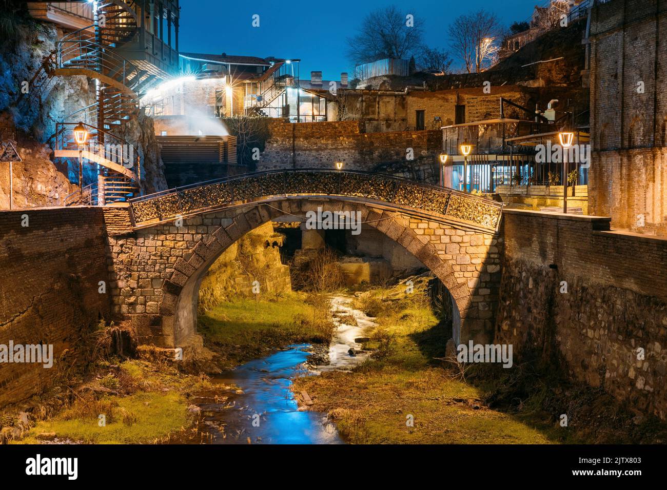 Tbilisi, Georgia, Night Scenic View Of old Bridge of Love in Bath District - Is The Ancient District Of Tbilisi, Georgia. Hanging houses above rvier Stock Photo