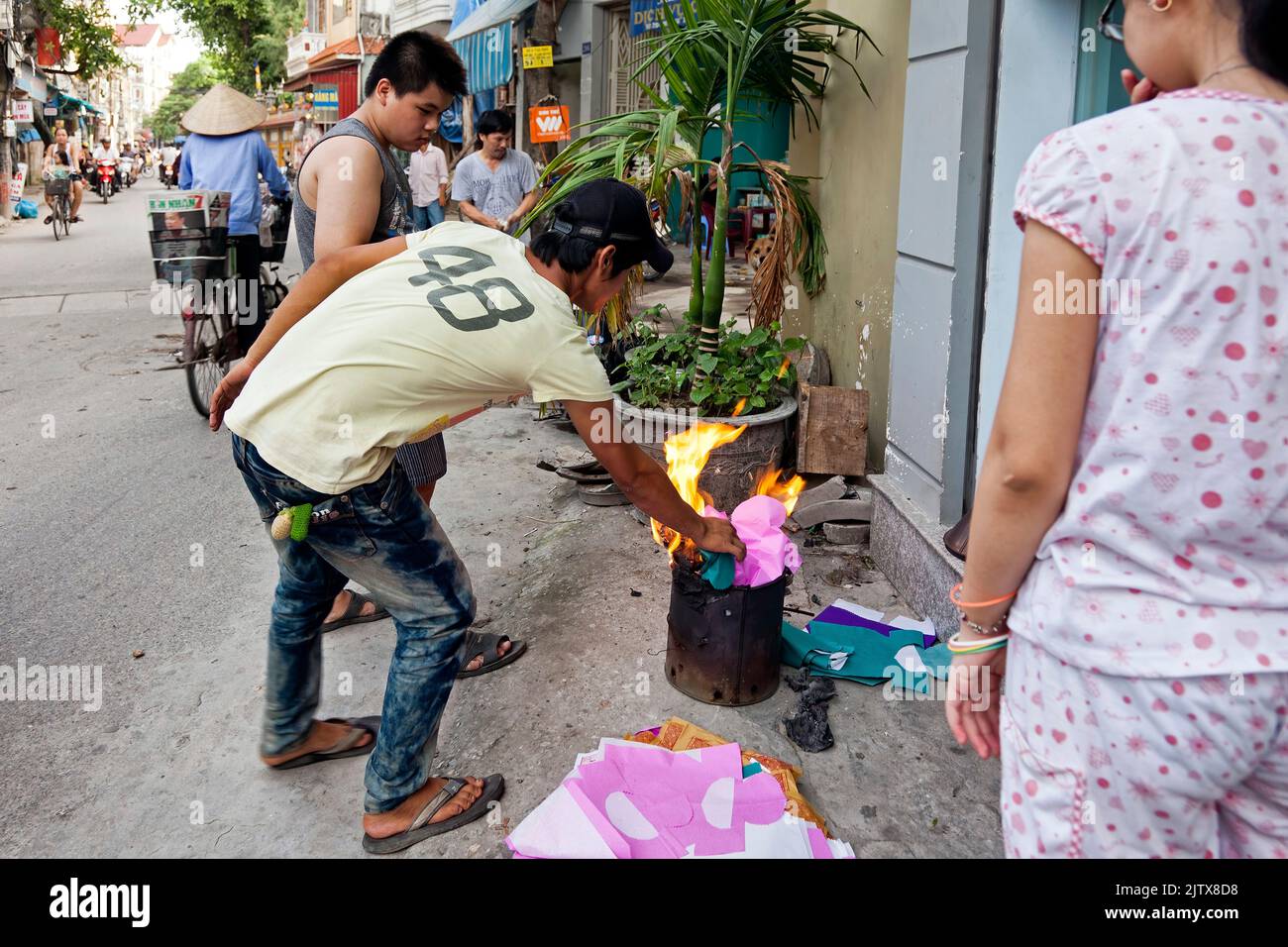 Vietnamese people burning paper in the street for Hungry Ghost festival, Hai Phong, Vietnam Stock Photo