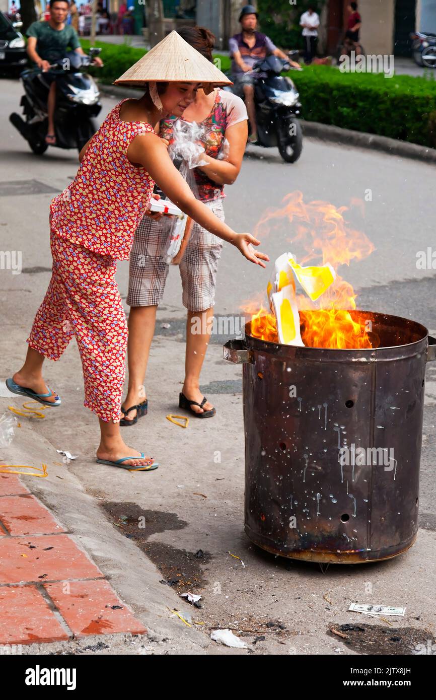 Vietnamese people burning paper in the street for Hungry Ghost festival, Hai Phong, Vietnam Stock Photo