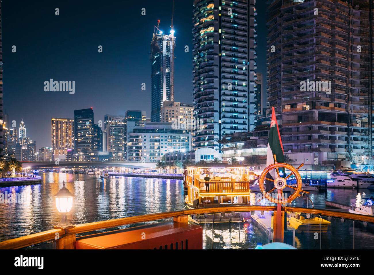 Night Walk On Tourist Boat, Sightseeing Boat Sailing On Dubai Marina. Night View Of Dubai Marina Is District in Dubai, United Arab Emirates. Stock Photo