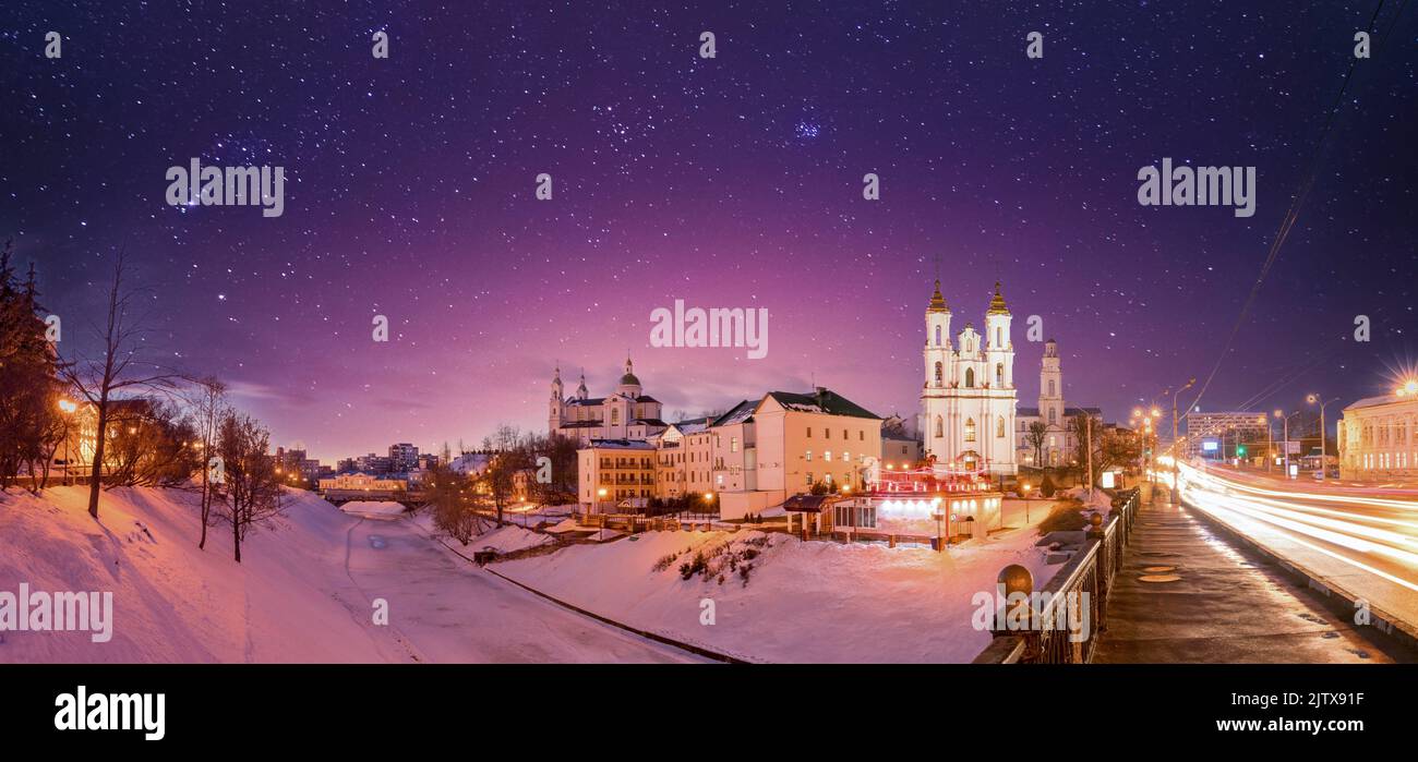 Vitebsk, Belarus. Holy Assumption Cathedral, Holy Resurrection Church And City Hall In Winter night. starry night sky stars above Famous Historic Stock Photo