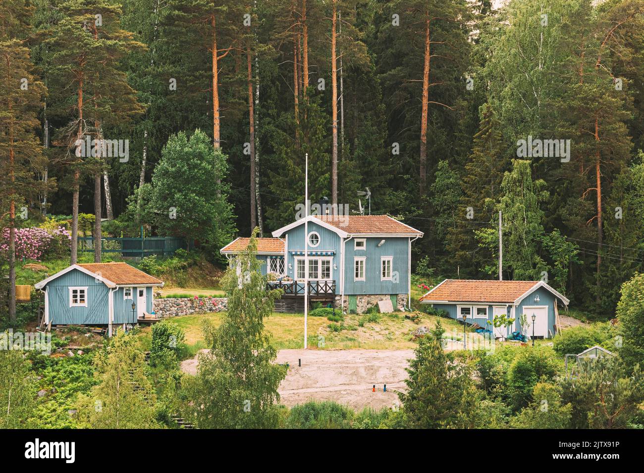 Sweden. Beautiful Swedish Wooden Log Cabins Houses In Forest In Summer Day. Stock Photo