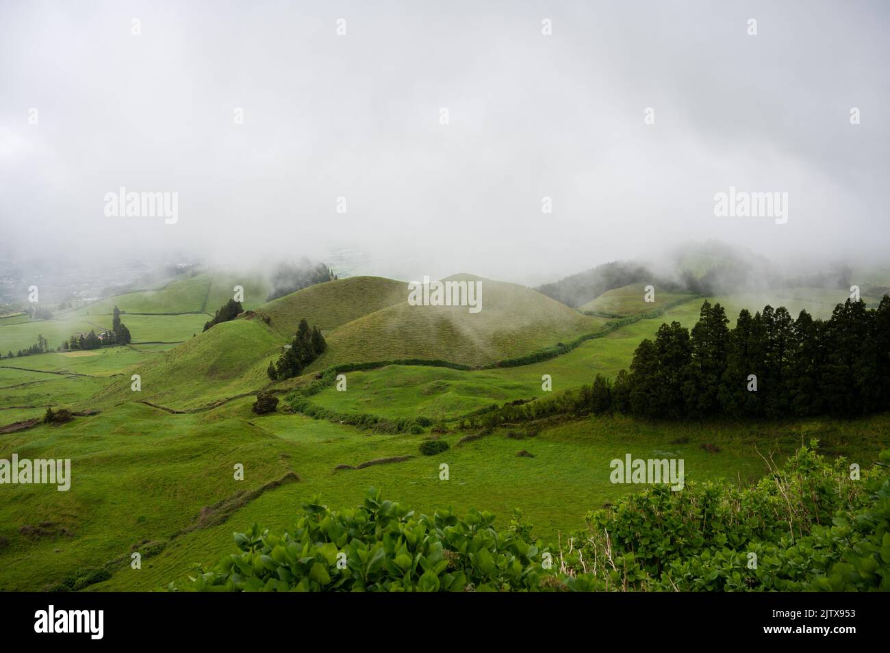 Green grass covered hills in the clouds Stock Photo Alamy