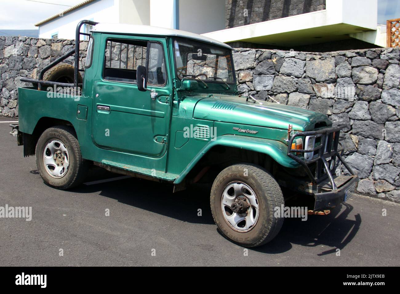 Toyota Land Cruiser pickup truck, 1970-s and 1980-s FJ43 model, parked on a sloping asphalt road, Cinco Ribeiras, Terceira, Azores, Portugal Stock Photo