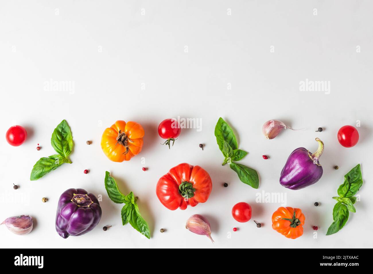 Creative layout made of tomatoes, pepper, garlic, basil. Flat lay. Top view. Food composition. Vegetables isolated on white background. Food ingredien Stock Photo